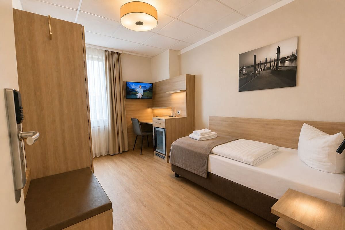 Una camera d'albergo con un letto, una scrivania, una televisione e un quadro appeso al muro.