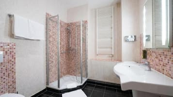 Suite | Badkamer | Een bad, een haardroger, handdoeken, zeep