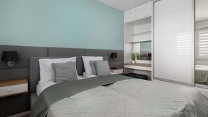 Ein modernes Schlafzimmer mit Bett, Nachttischen und einem Kleiderschrank.