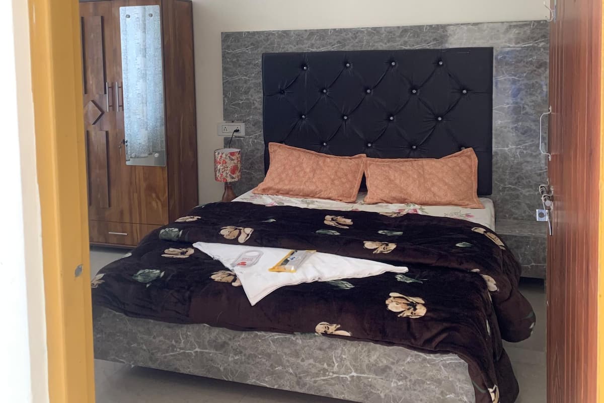 Quarto com uma cama, um guarda-roupa e um ventilador de teto.