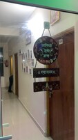 Un pasillo con un cartel en la pared, una puerta con el número 101, y una persona de pie al fondo.