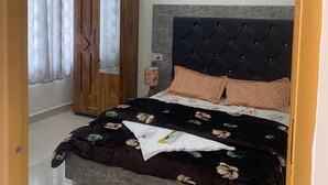Une chambre à coucher comprenant un lit, une armoire, un ventilateur de plafond et des tableaux accrochés au mur.