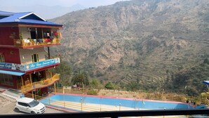 Un hôtel doté d’un balcon, d’une piscine et offrant une vue sur un paysage montagneux.