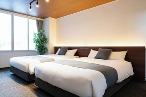 Une chambre d’hôtel avec deux lits, une grande fenêtre et une plante.