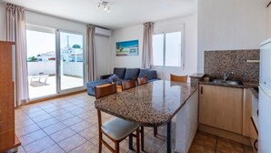 Un apartamento moderno con cocina, comedor y balcón.