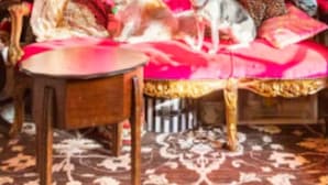 A room with a pink sofa, a small round table, and a patterned carpet. - Boutique Bijoux Garden Flat in Vibrant Oval (London)