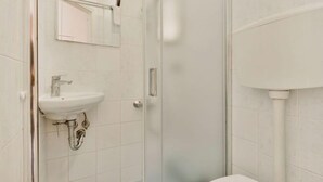 A bathroom with a white sink, a mirror, and a toilet.