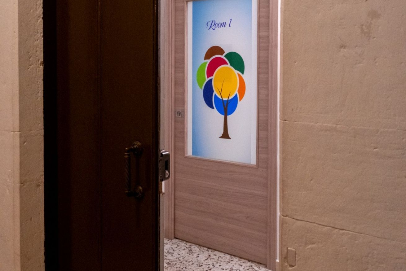 Eine Tür mit einem satinierten Glasspiegel, der einen farbenfrohen Baum und den Schriftzug 'Room 1' zeigt.