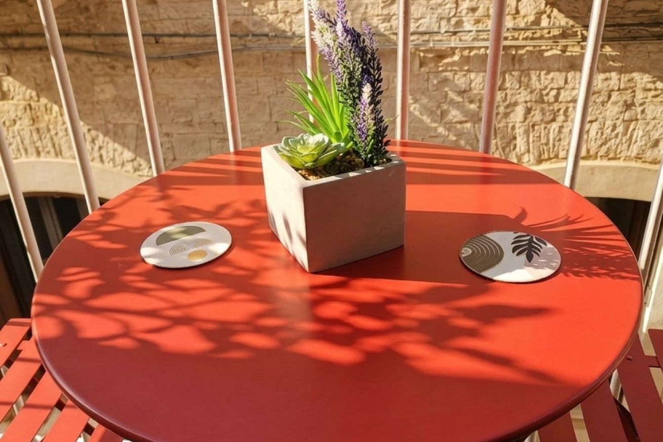 Een ronde tafel met een bloempot en twee onderzetters.
