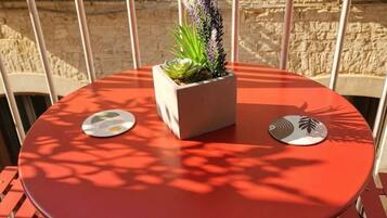 Een ronde tafel met een bloempot en twee onderzetters.