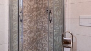 Ducha con puertas de vidrio y un pomo metálico.