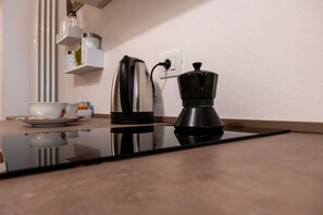 Eine Küche mit Kaffeemaschine, Wasserkocher und einer Tasse auf der Arbeitsfläche.