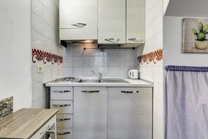 Dúplex, 1 cama Queen size, patio, vista al patio | Cocina privada | Frigobar, microondas y utensilios de cocina 