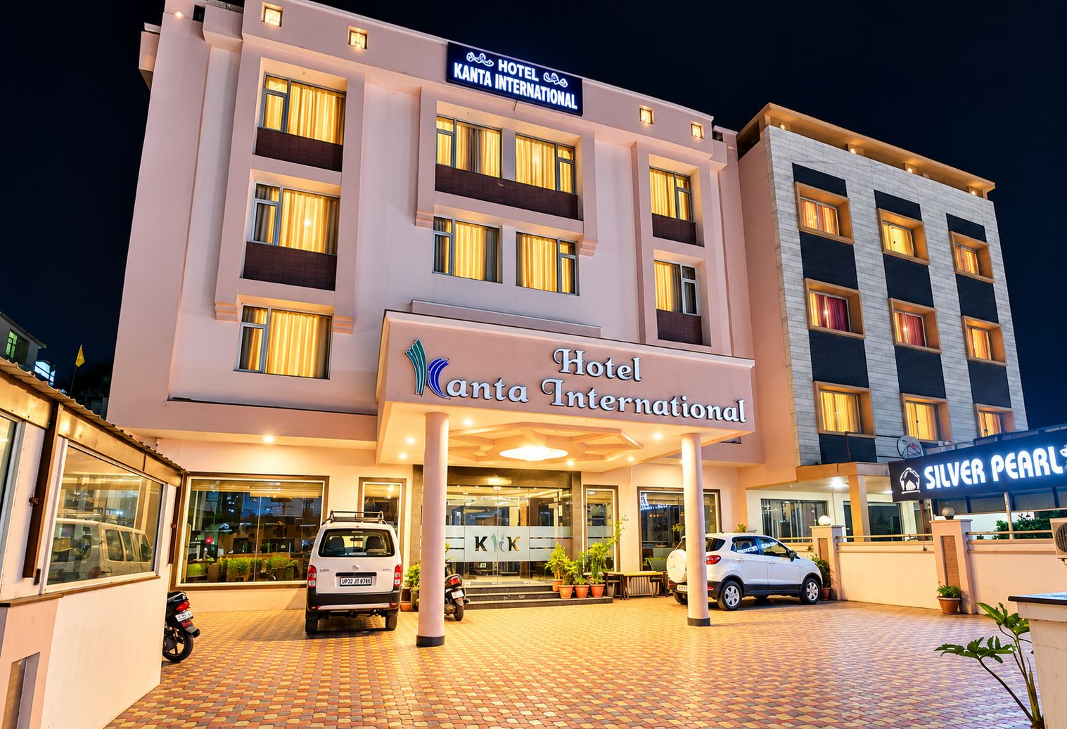 A hotel with a modern facade, multiple balconies, and a well-lit entrance.