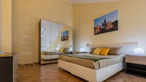 A bedroom with a bed, bedside table, lamp, wardrobe, and a mirror. - Loft San Carlo by Wonderful Italy (Turin)