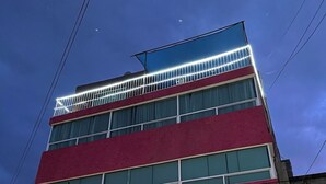 Un hotel de varios pisos con un llamativo letrero de 'HOTEL' en la fachada.