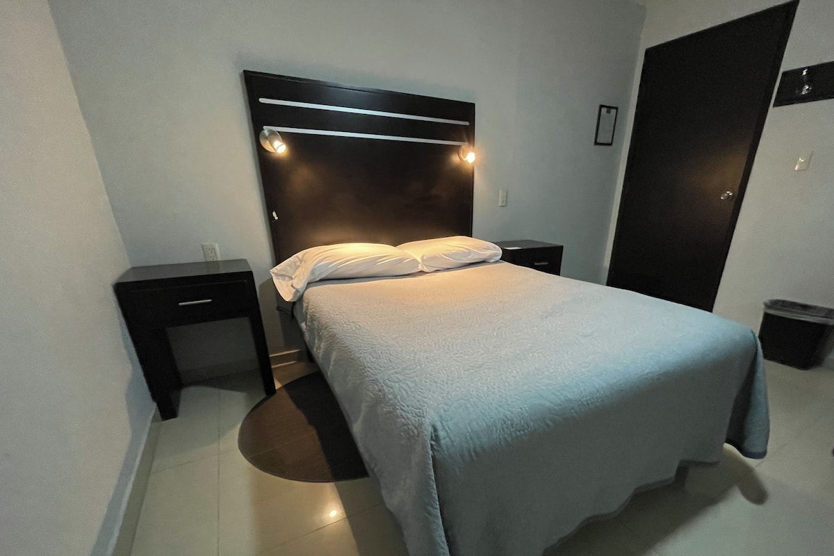 A neatly made bed with a headboard, two bedside tables, and a nightstand.