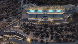 An aerial view of a modern building with multiple swimming pools, surrounded by landscaped areas and winding pathways. - Falasarna Village  (Kissamos)