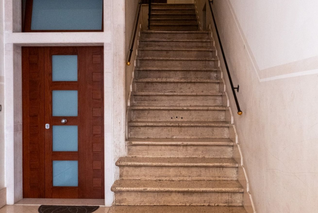 Eine Treppe mit einer Holztür und einem Geländer.