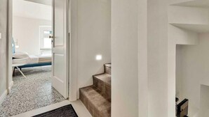 Hotellihuone, jossa on sänky, pieni työpöytä ja ikkuna.