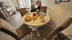 A dining area with a round table set for breakfast, including bread, pastries, and condiments. - Hello and welcome to Nordseeliebe! (Dangast)