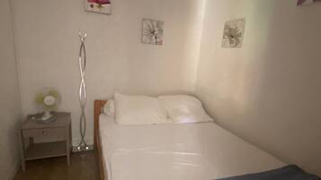Tabla de planchar con plancha y ropa de cama