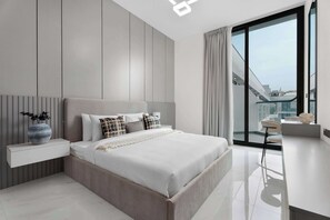 Ein modernes Schlafzimmer mit Bett, Nachttisch und Blick ins Freie.