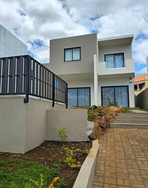A modern two-story building with large windows and a concrete facade. - Charming 3-bedroom villa in peaceful Albion with pool, Villa Serenity (Albion)