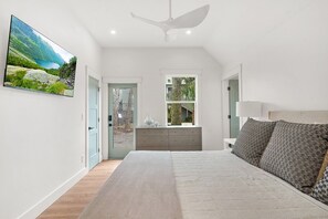 A bedroom with a bed, a dresser, a window, and a painting on the wall. - Beachside on B - Updated cottage just steps to beach (St. Augustine Beach)