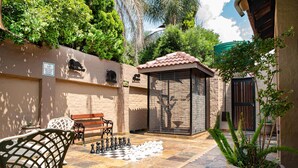 A courtyard with a chessboard, a bench, and a gazebo. - The Orion Guest House (Middelburg)