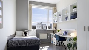 A modern bedroom with a bed, desk, and shelving unit. - For Students Only Rooms in Plymouth (Plymouth)