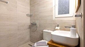 A bathroom with a shower, toilet, and sink. - Cozy Corner in Petralona (Athina)