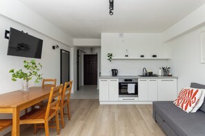 Studio | Privékeuken | Een koelkast, een kookplaat, een waterkoker, kookgerei, borden en bestek