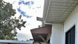 A residential building with a covered porch, multiple doors, and a gravel pathway leading to the entrance. - Relaxing Resort Stay at Ashelma Resort (Dauis)