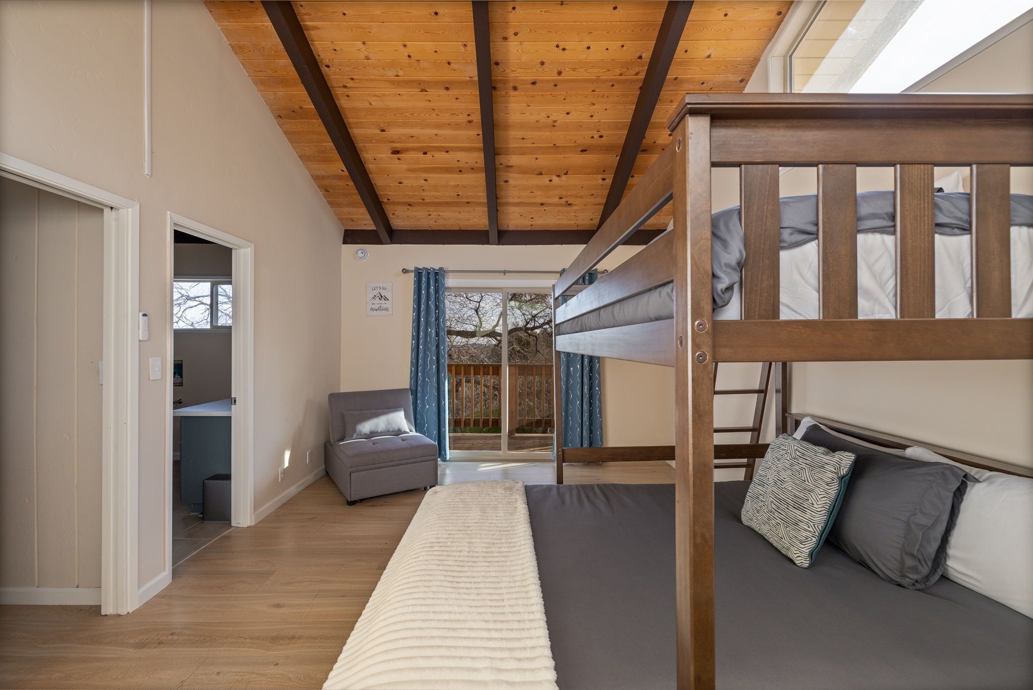 Un dormitorio con una cama litera, un sofá y un escritorio.