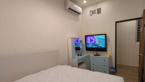 A bedroom with a bed, a dresser, a television, and an air conditioning unit. - Full 2B2B Accessible Home on the 1st Floor, Sleeps 5, in Xinyi District, Taipei. (Taipei City)