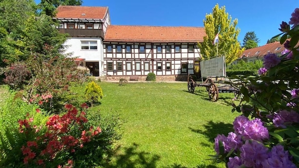 A traditional half-timbered building with a well-maintained lawn and garden in front.