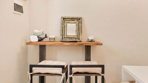 A room with a wooden table, two cushioned chairs, a mirror, and decorative items on the wall. - Sottovoce – Intimate vacation home in LericiIn the heart of Lerici, just steps from the sea and immersed in the tranquility of the village, Sottovoce is a small oasis of peace designed for those seeking a private and comfortable stay.This welcoming (Lerici)