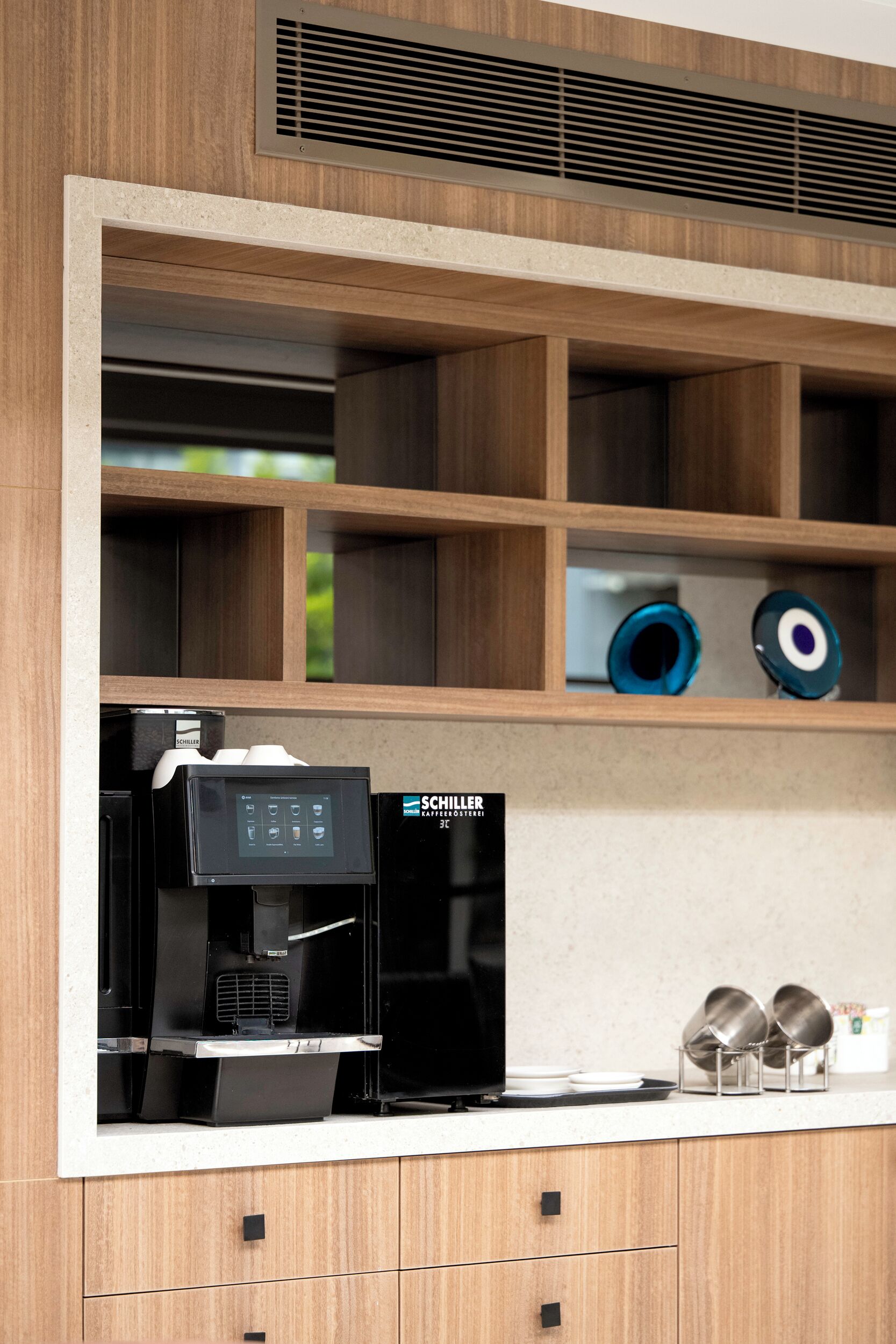Una cocina equipada con cafetera, estantes y utensilios de cocina.
