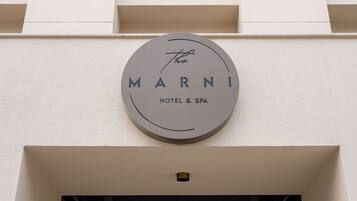 A circular sign with the words 'MARNI HOTEL & SPA' on a building facade.