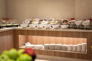 Una mesa de buffet con cuencos y platos dispuestos.