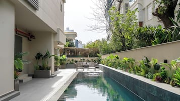 Una piscina al aire libre de temporada, sombrillas