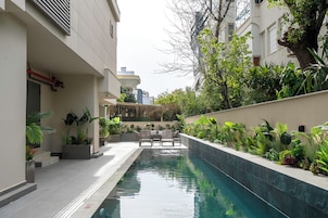 Una piscina al aire libre de temporada, sombrillas