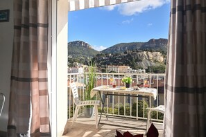 A balcony with a table, chairs, and a potted plant. - Apartment 'Le Panorama' with Sea View, Balcony, Wi-Fi and Parking (Cassis)