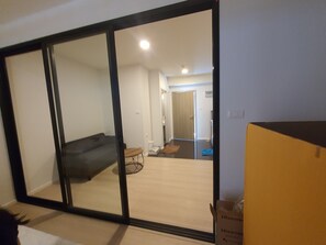 Ein Zimmer mit einer Schiebetür und Zugang zu einem Wohnbereich, einem kleinen Tisch und einem Sessel.