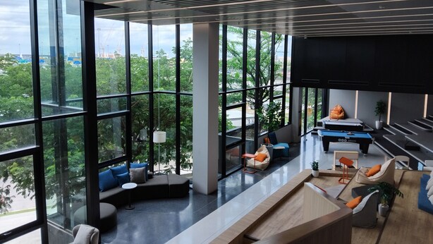 Een modern interieur met grote ramen, een rond zithoek en een biljarttafel.