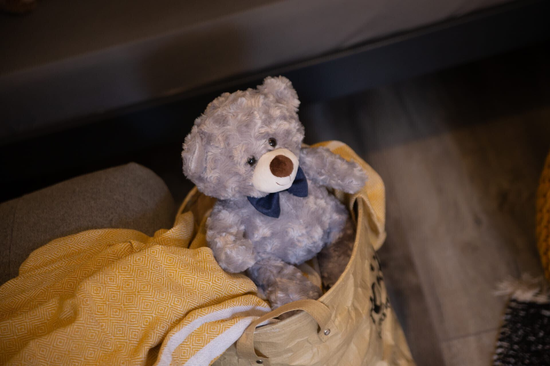 A teddy bear in a beige bag.