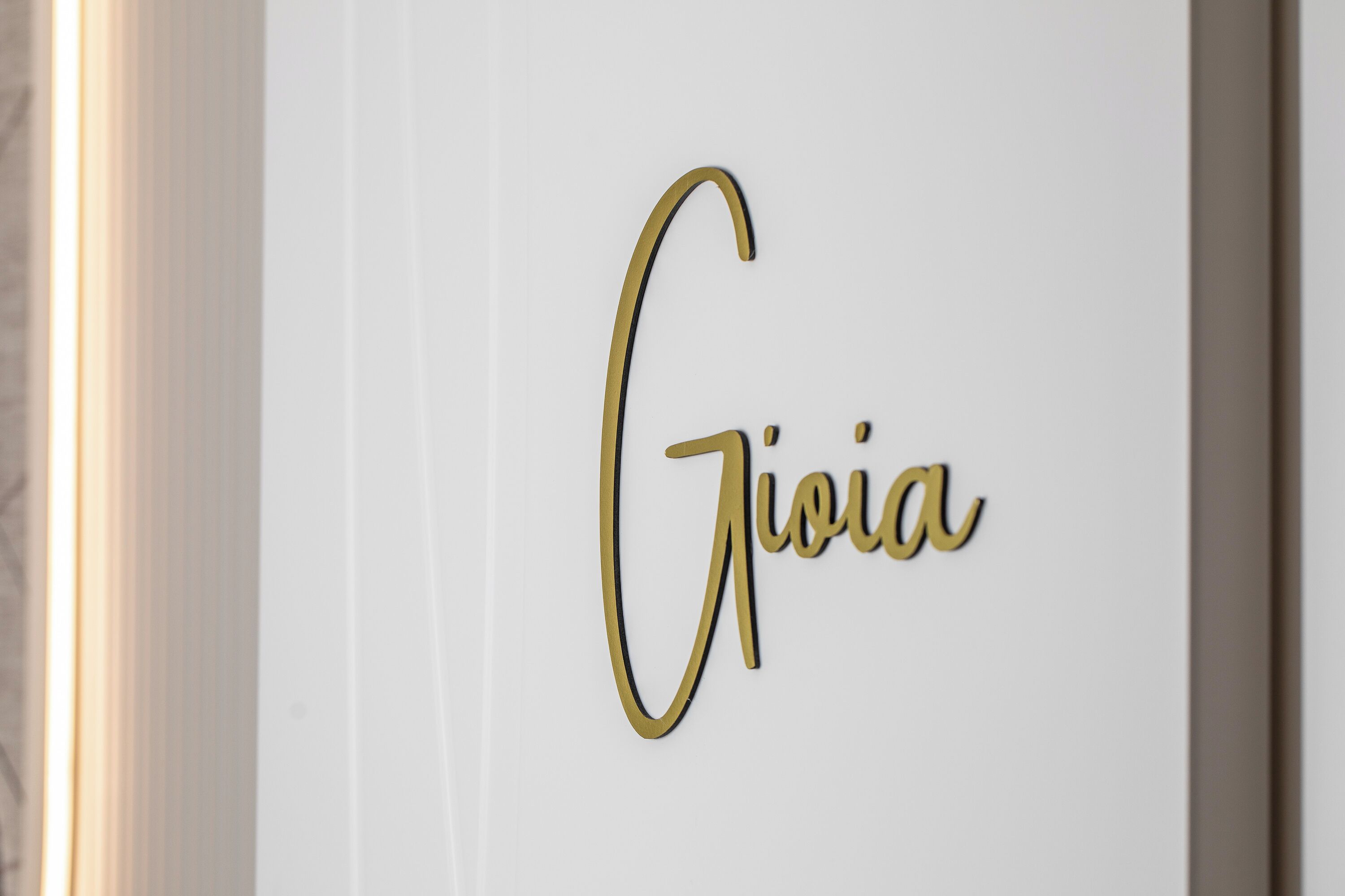 O nome "Giulia" em letras douradas numa parede branca.