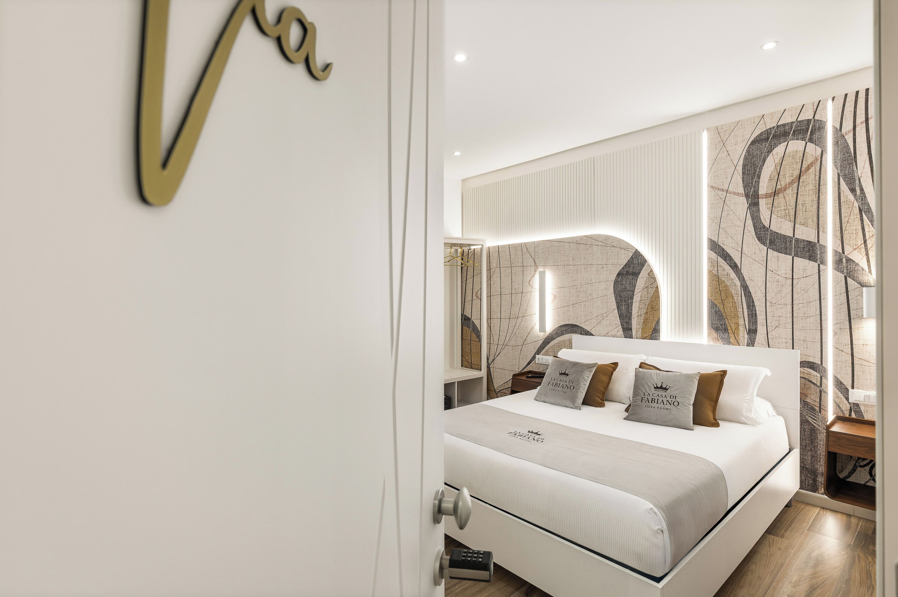 Una camera da letto moderna con un letto grande, un comodino e una parete decorata con arte astratta.