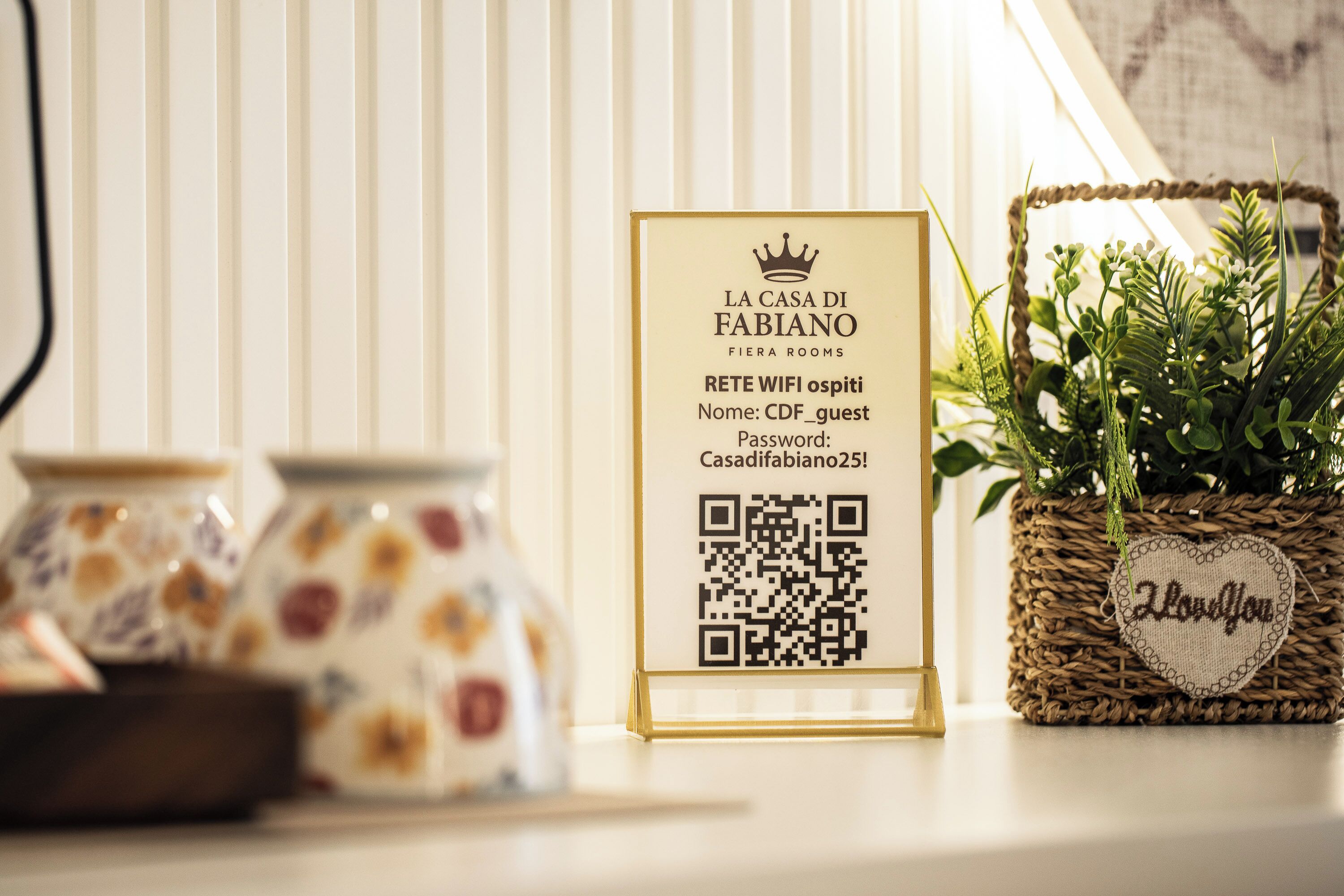 A sign with QR code for WiFi access, a basket with a heart-shaped tag, and ceramic jars.